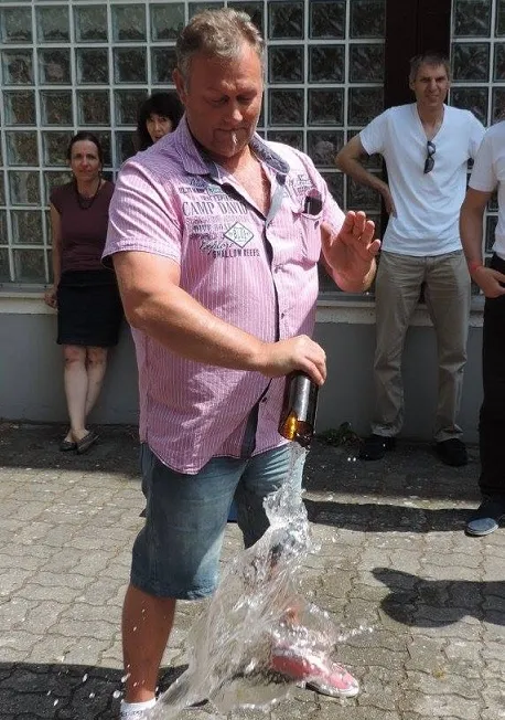 Bernhard bei einer Live-Performance mit einer Flasche, Zuschauer im Hintergrund
