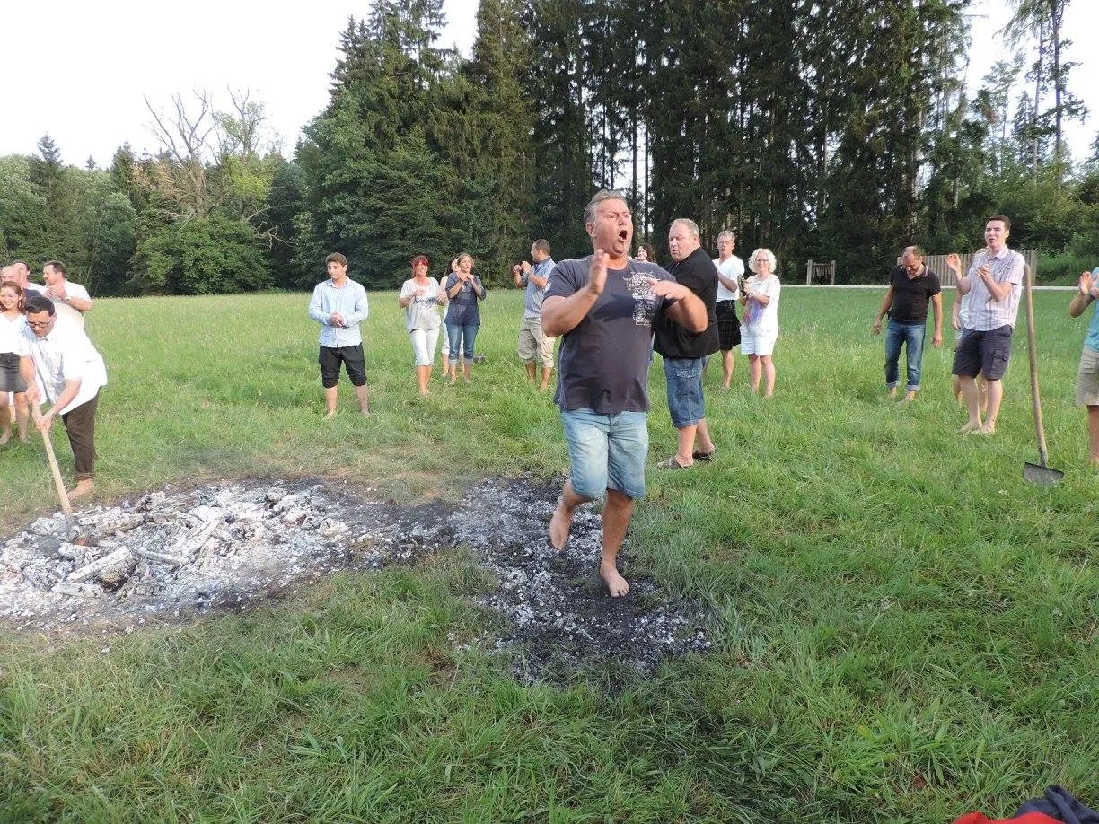 Bernhard läuft barfuß über die Glut, um ihn herum klatscht die Gruppe